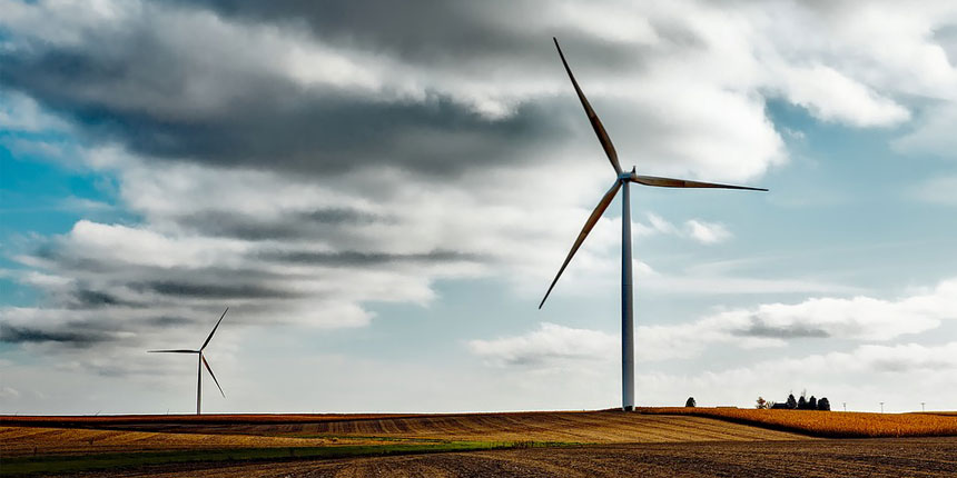 Unos molinos de viento en un prado que aportan algunas ventajas y desventajas de la energía eólica