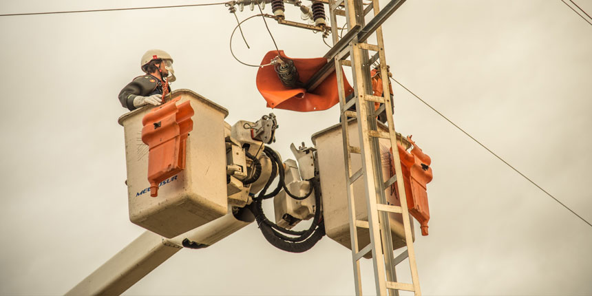 Dos operarios de Melfosur realizando servicios energéticos en una línea aérea eléctrica